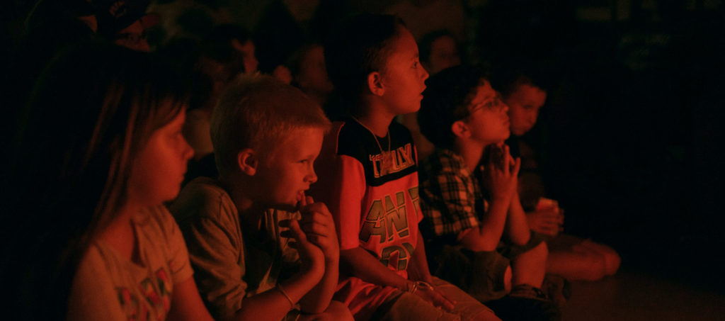 Campers enjoying a story by the fire.